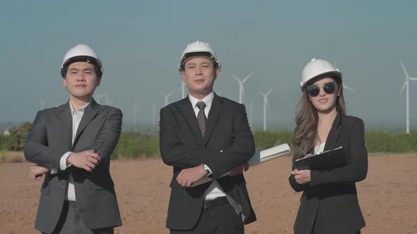 Team Asian engineers in wind turbine farm