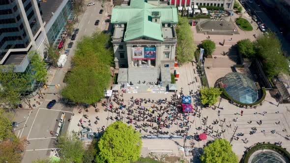 Overhead view of crowd gathered at art gallery in Vancouver. Drone shot over Robson Square in downto