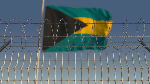 Flying Flag of Bahamas Behind Barbed Wire Fence