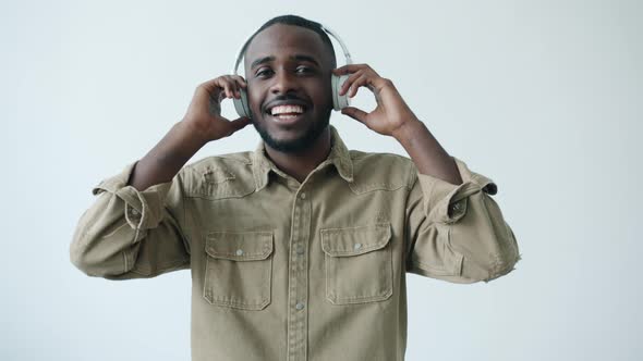 Slow Motion Portrait of African American Student Wearing Headphones Dancing on White Background