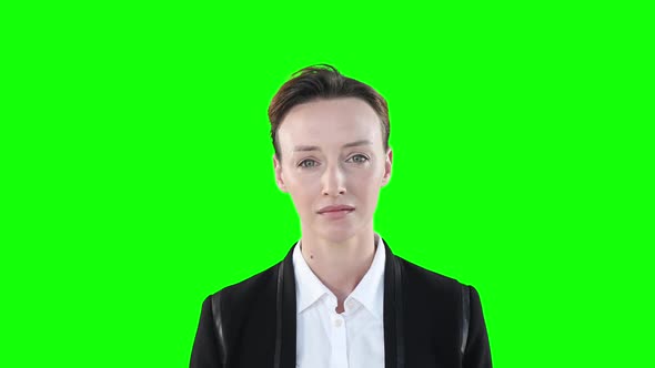 Sad Caucasian woman looking at camera on green background
