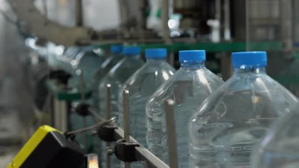 Full five-liter bottles move along the conveyor. Drinking water production line