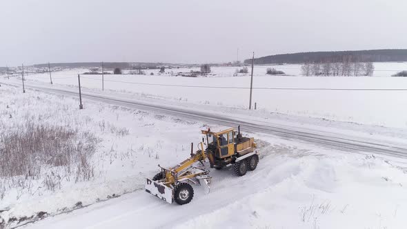 Aerial view of Snowblower Grader Clears Snow Covered Country Road in the field 18