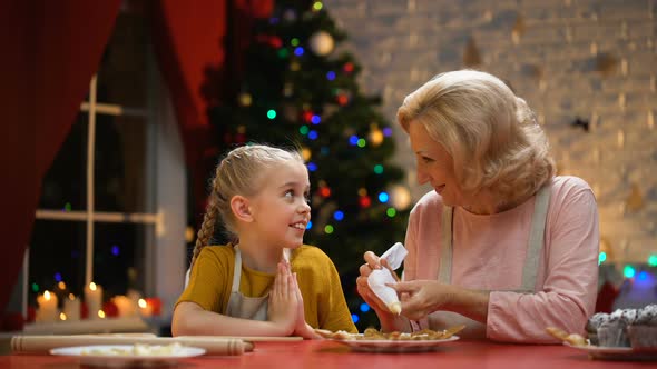 Cheerful Granny and Girl Decorating Cookies for Christmas Party, Happy Holidays