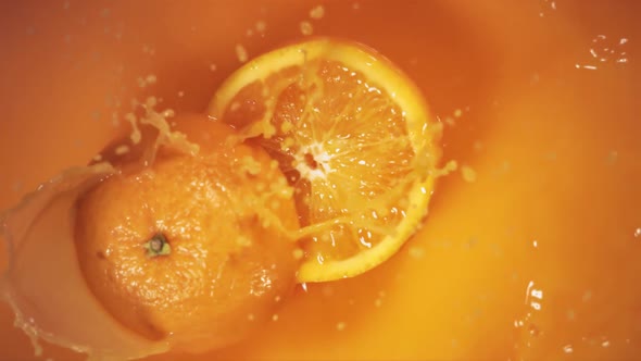 Orange Fruit Falling on Juice with Splash and Divided in Half