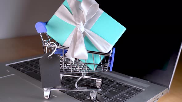 Small Shopping Cart with a Gift Inside and a Black Tag