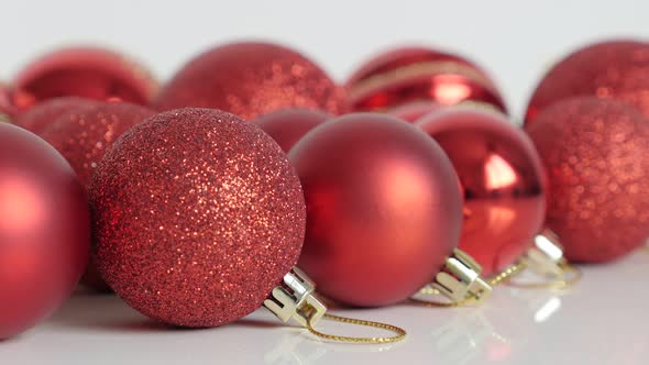 Lot of red baubles on white close-up 4K footage