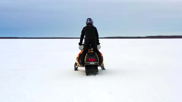 Following Snowmobile On The Ice