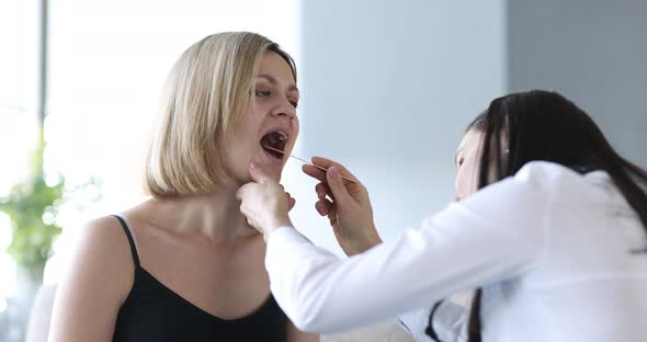 General Practitioner Examining Patient Throat with Spatula at Home