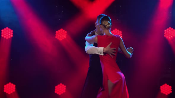 Graceful Argentine Tango Among Smoke and Bright Red Neon Lights in a Dark Studio