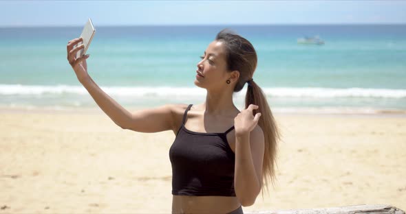 Ethnic Sportswoman Taking Selfie on Beach