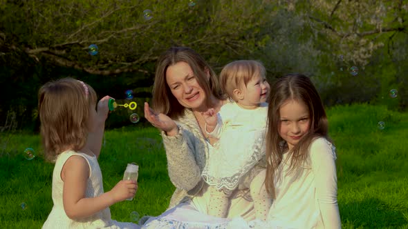 Mom with Three Daughters Rest in the Park