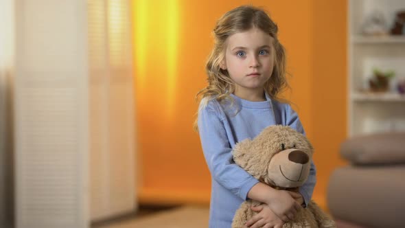 Adorable Sad Little Girl Hugging Favorite Teddy Bear Feeling Lonely in Orphanage