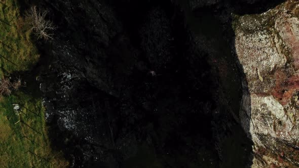 Aerial ascent from the darkness of the slate mine to a high angle of the mine gap. Snowdonia,Wales,U