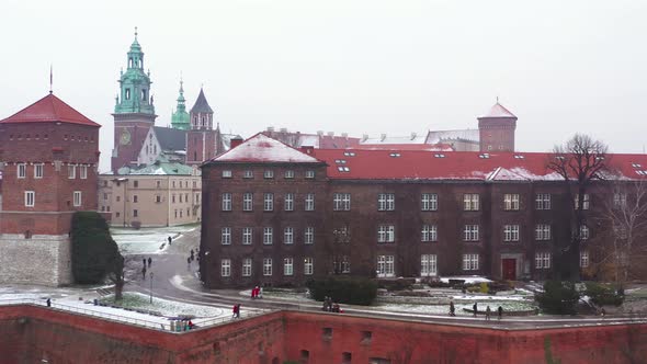 Aerial View of Wawel Royal Castle and Cathedral Park Promenade and Walking People in Winter