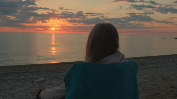 Closeup Shot of Woman Sitting on Camping Chair and Drinking Coffee