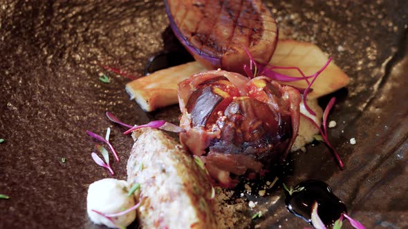 Close-up pan of grilled aubergine, king oyster mushrooms served with prosciutto wrapped fig, gorgonz