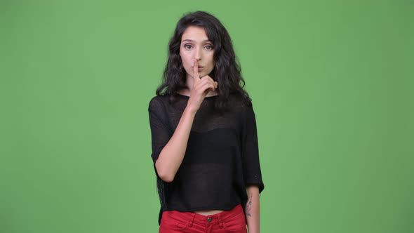 Young Beautiful Woman with Finger on Lips