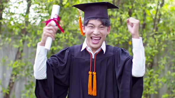 Asian Graduate man wear cap and gown so proud smile and happiness in Commencement day