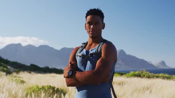 Portrait of african american man cross country running in mountain countryside looking at the camera