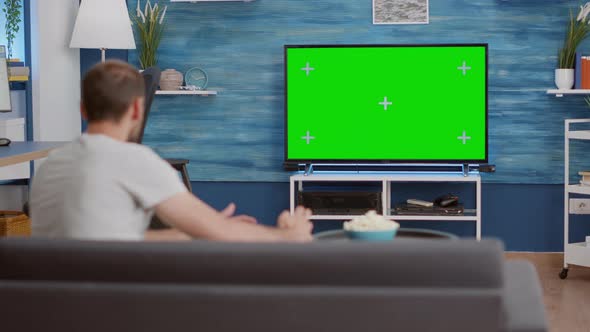 Man Sitting on Sofa Watching Sport Game on Green Screen Tv Mockup Encouraging Favourite Team