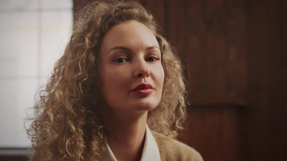 Handheld Portrait of a Curly Caucasian Woman Looking at Camera