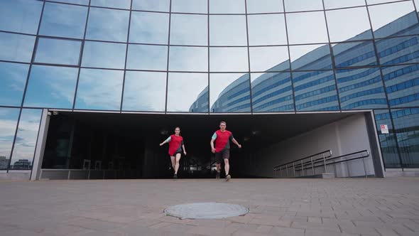 Free Running Young Peoples Doing a Somersaults Near Modern Building Guy and a Girl Runs and Perform