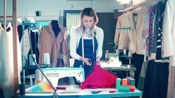 Female Designer is Cutting Fabric in the Studio