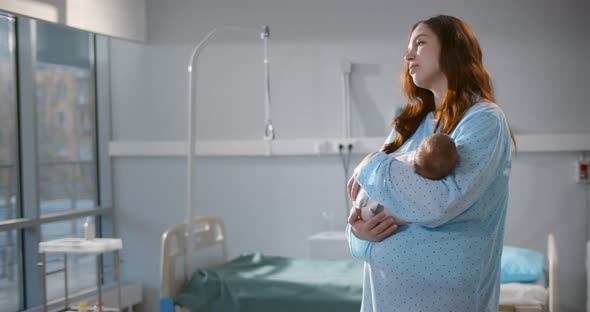 Caucasian Mother Holding Her Newborn Baby After Labor in Ward at Hospital