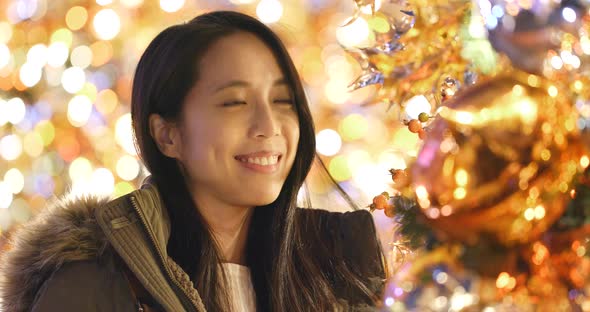 Asian Woman looking at the christmas tree decoration 