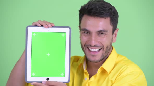 Face of Happy Young Hispanic Businessman Showing Digital Tablet