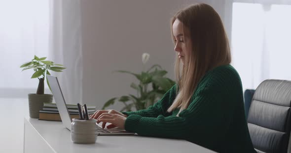 Female Writer or Journalist Is Working From Home Typing Text in Notebook Sending By Internet Young