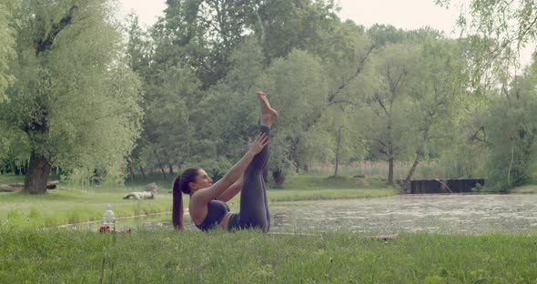 Fit Woman Doing Morning Yoga Exercises in the Park