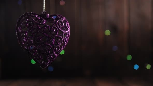 Christmas Purple Shiny Heartshaped Toy on a Wooden Background