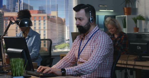 Man Working at His Desk in a Call Center