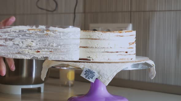 Woman Chef Takes Off the Plastic Covering From the Sides of a Cake