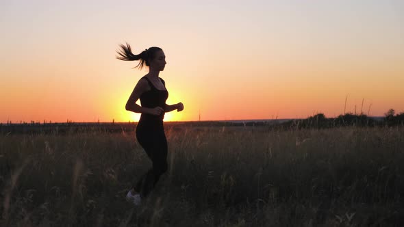 Young Fitness Sport Woman Running on Road at Sunset