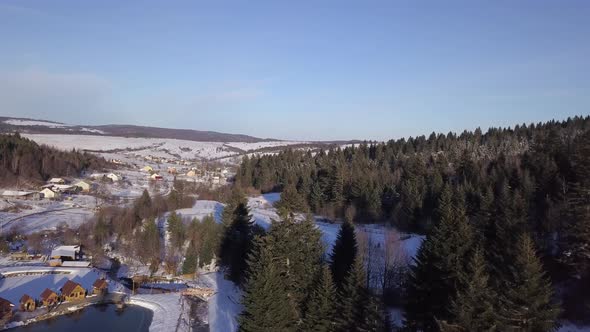 Aerial View of Winter Landscape with Snowy Hills and Trees