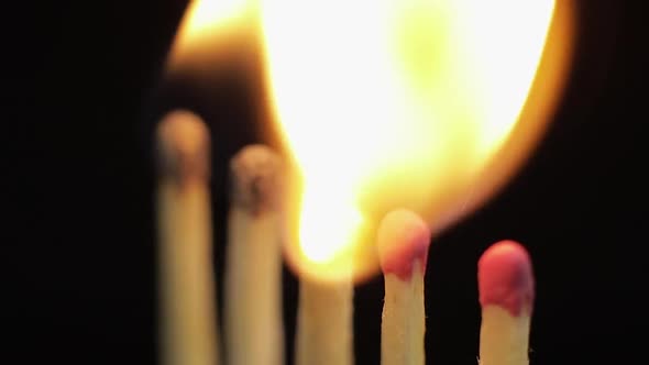 Matches Light Up One By Another in Series on Black Background alt