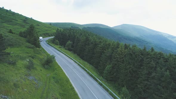 Aerial View of White Delivery Van Driving Through Mountains