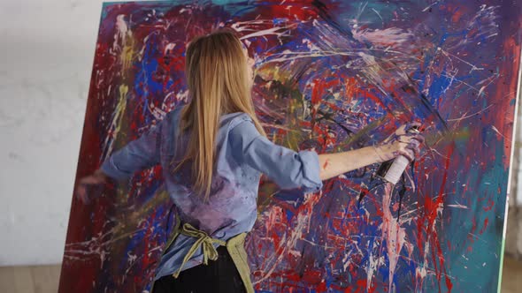 Passionate Woman Drawing Abstact Picture Using Spraying Paints in Art Studio