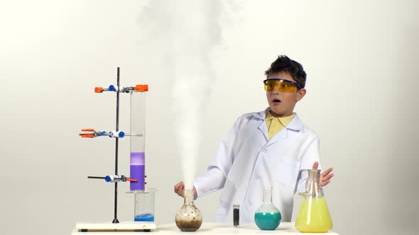 Little Boy Chemist in Uniform, Protective Glasses Has Successfully Tested the New Formula and