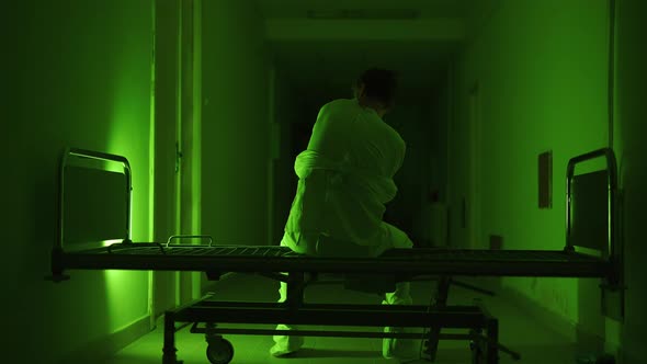 A Mad Male Patient in Straitjacket is Going Crazy in a Mental Hospital