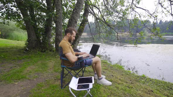 Working with computer by the lake.