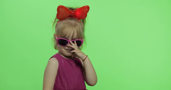 Girl Dancing in Purple Dress, Sunglasses and Red Ribbon on Head. Chroma Key