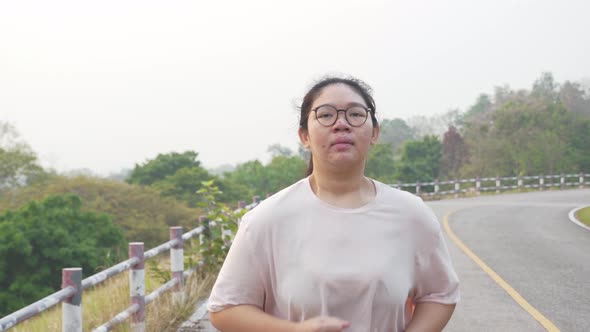 Fat Asian woman with pimple running outdoor.