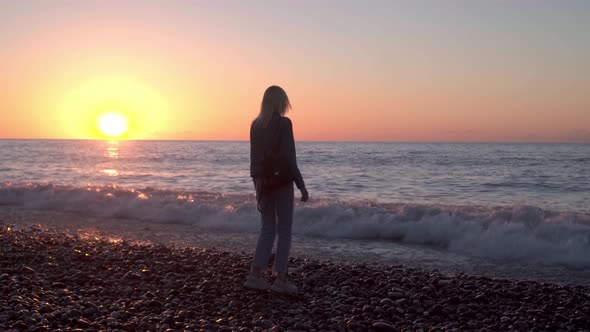 girl stands by sea and dreams. Romantic walk along beautiful shore. waves sea.