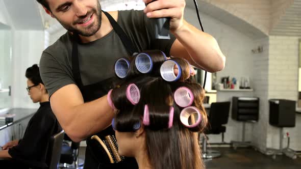 Male hairdresser styling customers hair