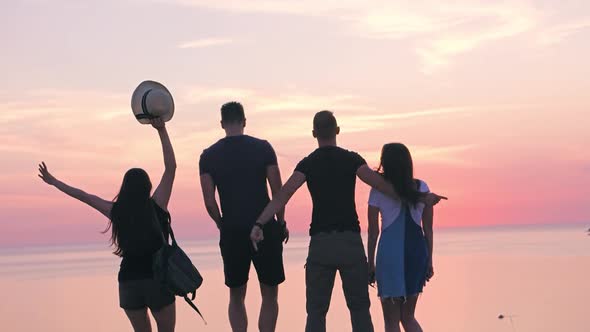 Group of Active Young Travelers Enjoying Success Jumping and Dancing Rear View