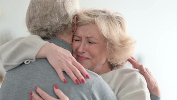 Upset Old Woman Hugging Partner at Home